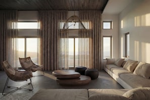 A spacious living room with a large window, a hanging light fixture, a sofa, and two chairs. - Dreamscape Villa, Anzo Villas (Thira - Santorini)