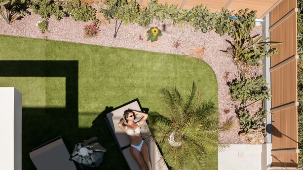 A rooftop pool area with a sun lounger, a small table with drinks, and a poolside chair. - Premium Seaview Suite With Heated Pool and Private Parking (Rethymno)