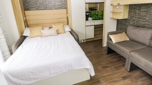 Un dormitorio con cama, sofá, escritorio y kitchenette.