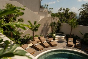 A poolside area with lounge chairs and a hot tub. - MIRA Hotel & Recovery  (Uluwatu)