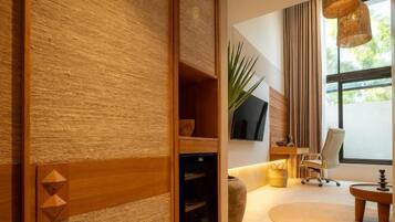 A modern interior with a wooden textured wall, a flat-screen TV, a comfortable seating area with a sofa and armchairs, and a large window with curtains.