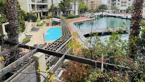 Ein Hotel mit Pool, Außenbereich und Blick auf das Wasser.