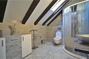 A modern bathroom with a freestanding toilet, a glass shower enclosure, and a sink with a large basin. - Tressette, Charm Studio in Split (Split)
