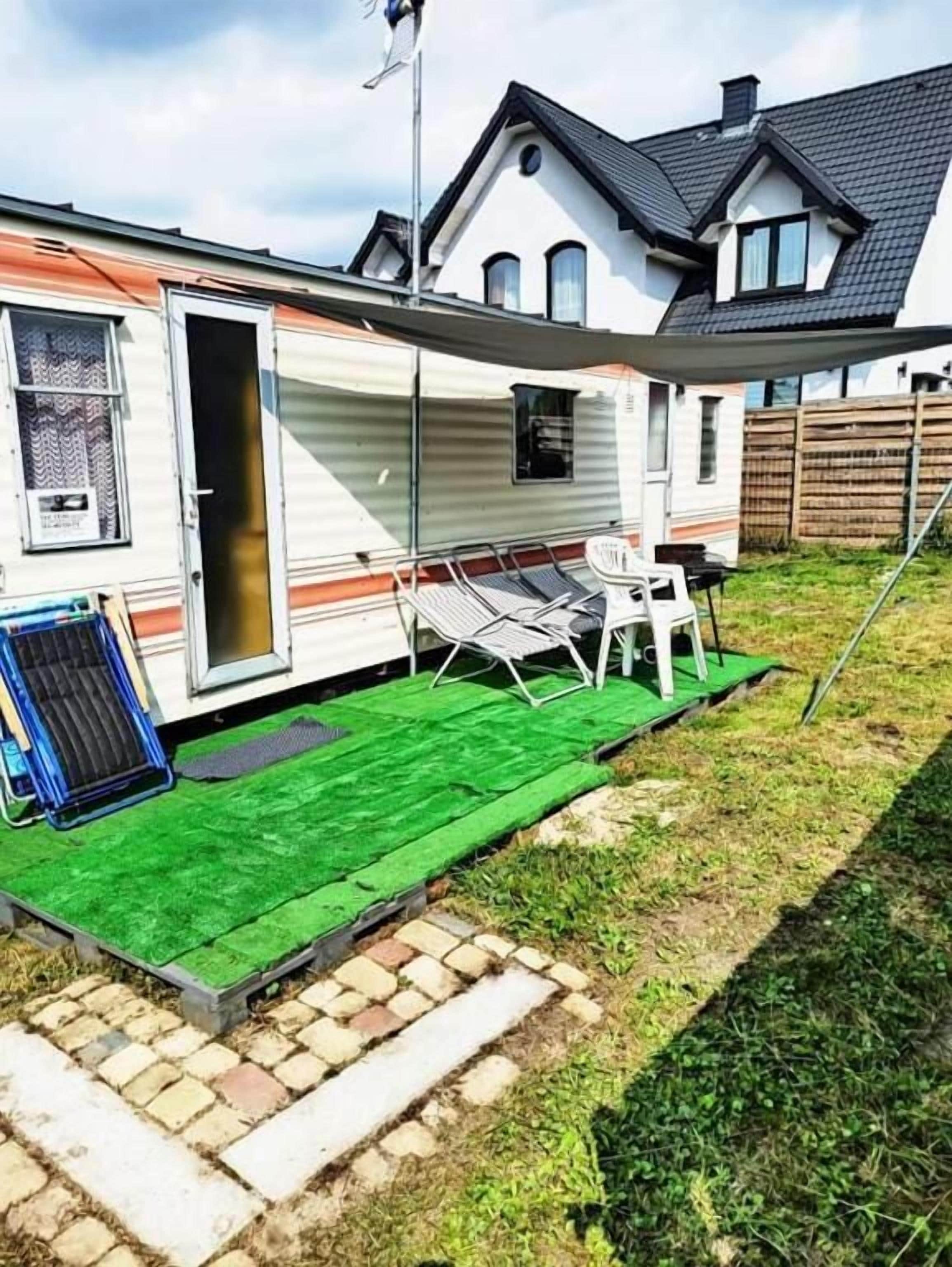 Ein Wohnmobil mit Terrasse, einem Tisch und einem Stuhl.