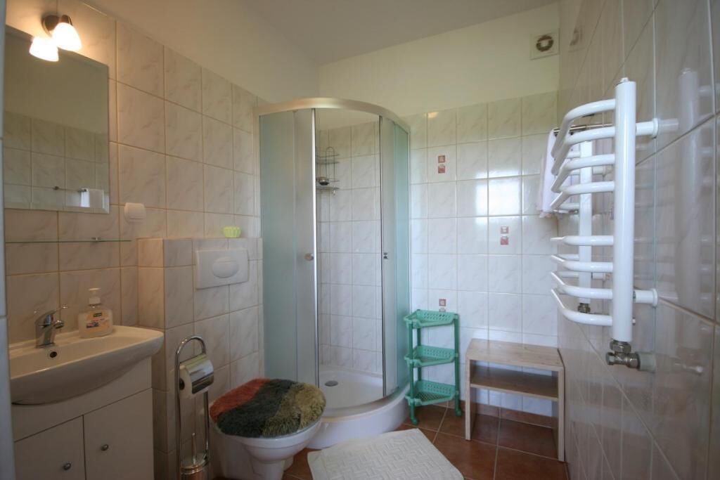 Ein Badezimmer mit Waschbecken, Toilette, Dusche und Handtuchhalter.