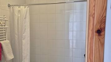 A bathroom with a shower, toilet, and sink.