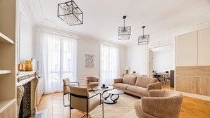 A spacious living room with a fireplace, a sofa set, a coffee table, and a dining area. - Luxury - High-End - Champs-Élysées - Paris 8 - AC (Paris)