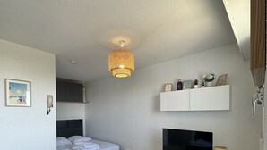 Ett modernt sovrum med en säng, en tv och ett soffbord i glas.