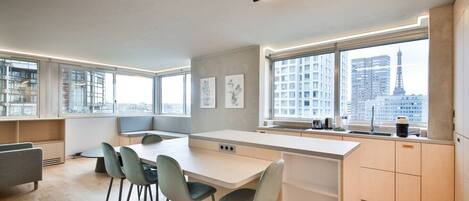 Una cocina moderna con comedor, ventanas amplias y vistas a la ciudad.