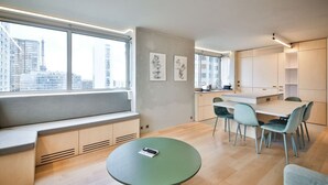Eine moderne Küche mit Essbereich, großen Fenstern und Blick auf die Stadtlandschaft.