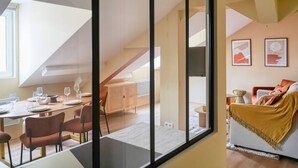 A modern interior with a dining area, a sofa, and artwork on the walls. - 4D. Modern - 2 People - 1 Bedroom - Business - Paris 15 - AC (Paris)