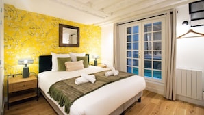 Ein Hotelzimmer mit Bett, Nachttischen, einem Spiegel und einem Fenster mit Blick.