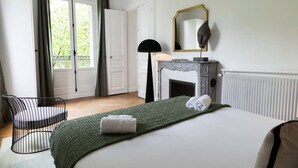 A bedroom with a bed, a chair, a fireplace, a mirror, and a view of the outdoors. - A3. Champs-Élysées#4-bedroom#Arc de Triomphe#AC (Paris)