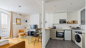 Un appartement moderne comprenant une cuisine, un coin repas et un salon.