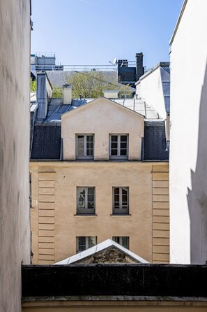 A building with a beige facade, multiple windows, and a sloped roof. - 2-4 people—Panthéon—Sorbonne—Jardin des Plantes (Paris)