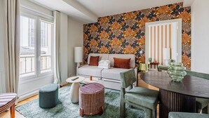 A modern living room with a sofa, a dining table, and a patterned wall. - Modern#ArcDeTriomphe#4people#ChampsÉlysées (Paris)