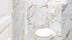 A bathroom with marble walls, a toilet, and a shower area. - Modern#ArcDeTriomphe#4people#ChampsÉlysées (Paris)