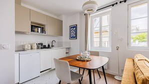 A modern kitchen with a dining table, chairs, and a sofa. - 3. Apartment - 2 people - 1 bedroom - Mouffetard - Sorbonne (Paris)