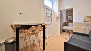 Een moderne kamer met een eethoek, een bed en een slaapbank.