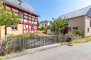A traditional half-timbered house with a wooden fence and a stone wall in the foreground.