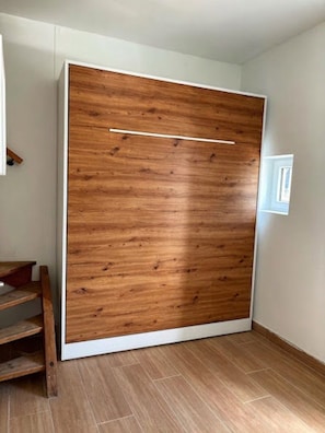 Ein Zimmer mit einer großen Schiebetür, Holzboden und einer weißen Wand.