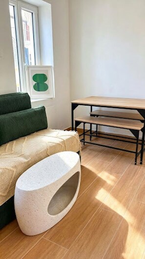 Ein Zimmer mit einem Bett, einer Bank und einem Fenster.