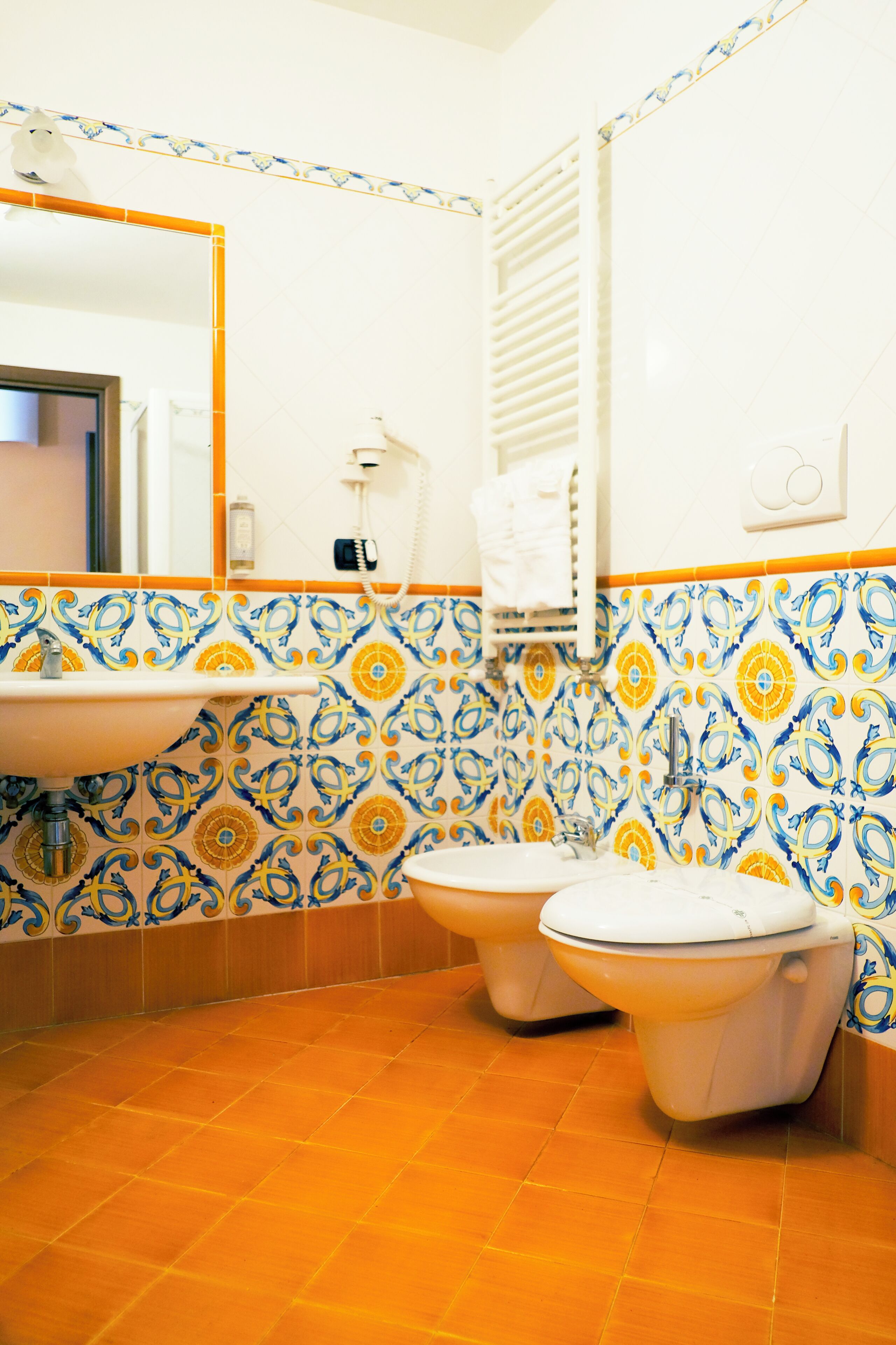 Un baño con dos inodoros, un lavabo y un espejo.