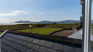 A rooftop with a view of a grassy area and distant mountains. - Traditional Cottage in Waterville on the Wild Atlantic Way (Waterville)