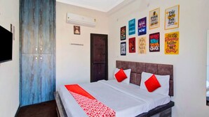A hotel room with a bed, a wardrobe, a television, and motivational posters on the wall. - Hotel Shree Kanha (Jaipur)