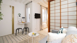A room with a tatami mat, a TV, a small table with a glass, and a sofa. - 21-Studio for 2 People-Central-Le Marais-Paris 4th (Paris)