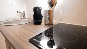A kitchen with a modern induction cooktop, a coffee maker, and a kettle. - 21-Studio for 2 People-Central-Le Marais-Paris 4th (Paris)