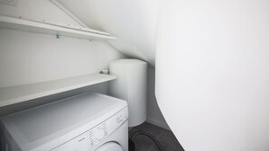A laundry room with a washing machine, a dryer, and a shelf above the machine. - 5#Studio#2 People#Paris 15#Retail#AC (Paris)
