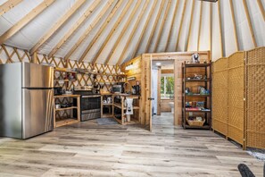 Eine kleine Küche mit Kühlschrank, Backofen und Holzböden.