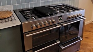 A kitchen with a stainless steel stove, oven, and a tiled backsplash. - Escape to Ardchoile | Sleeps 10 with Hot Tub, Log Fire & Games Room (Kingussie)