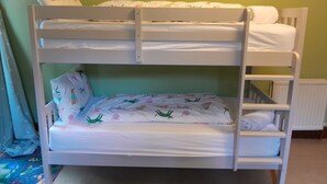 A bunk bed with a lower bunk featuring a patterned bedspread and pillows, and a top bunk with a plain white mattress. - Escape to Ardchoile | Sleeps 10 with Hot Tub, Log Fire & Games Room (Kingussie)