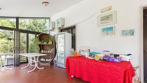 Une pièce avec une table rouge, un réfrigérateur et une chaise.