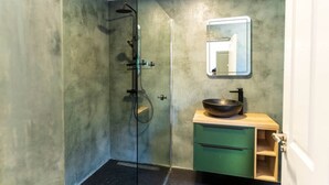 A bathroom with a glass shower enclosure, a wooden vanity with a bowl sink, and a green cabinet. - Modern Studio Apartment in the Heart of Cahersiveen (Cahersiveen)
