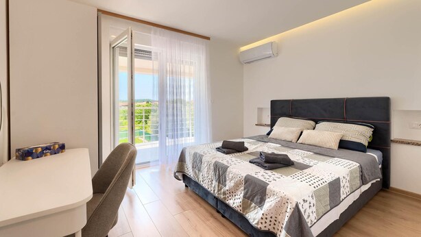 Un dormitorio con cama, escritorio y silla.