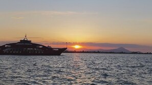A boat with 'TSOS' written on its side, sailing on water with a sunset in the background. - Oropos Relax View (Oropos)
