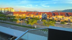 A residential area with multiple red-roofed houses, a clear sky, and a road with cars. - Spacious 3-bedroom neighborhood apartment with AC in Langkawi (Langkawi)