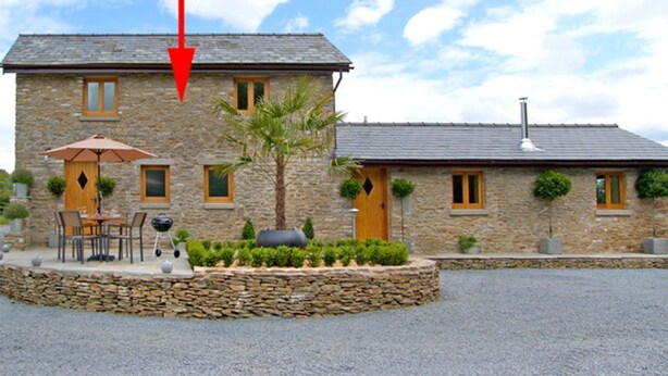 A stone building with a gravel driveway, a patio with outdoor furniture, and a palm tree. - Valley View (Ross-on-Wye)