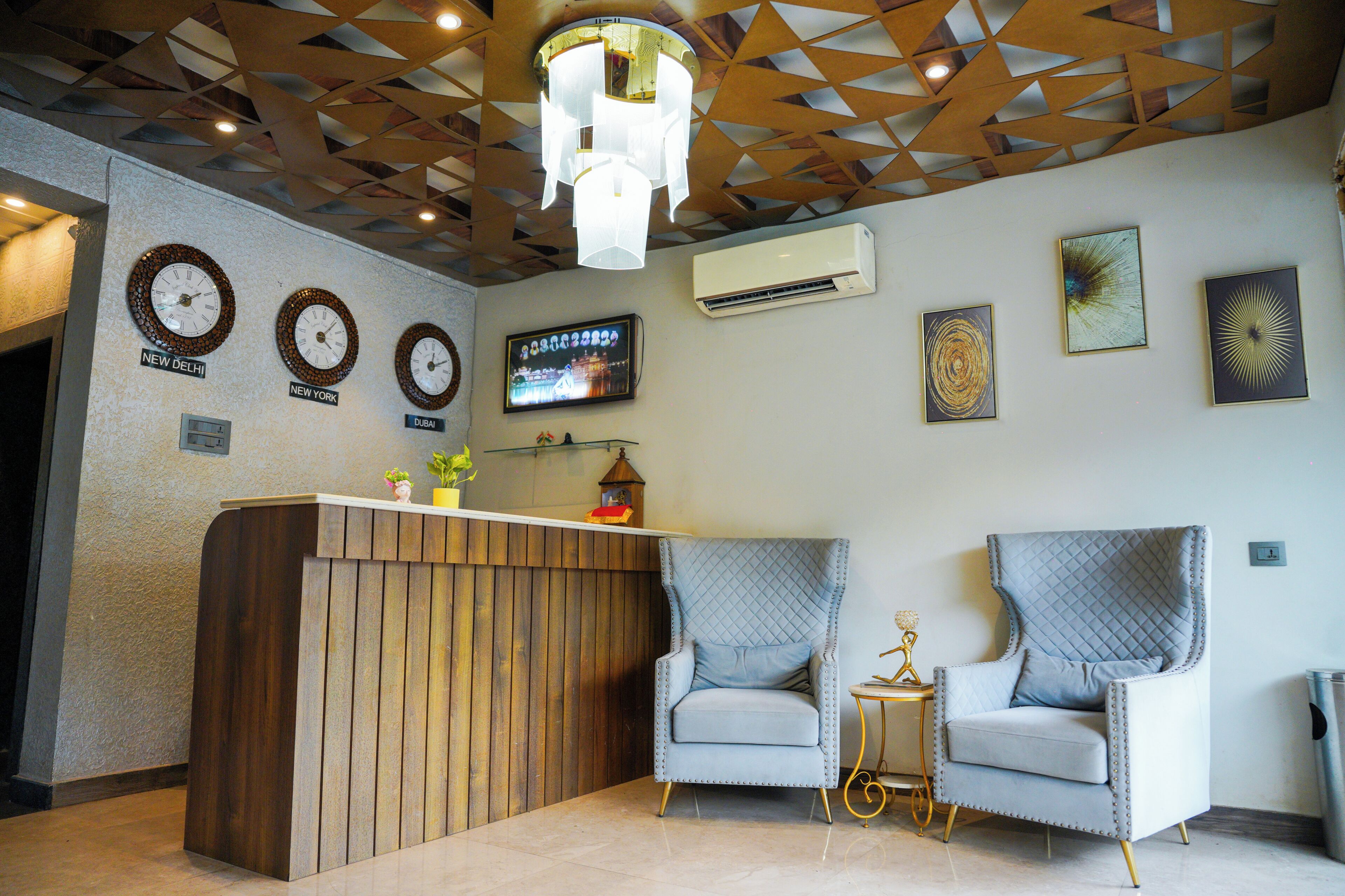 A reception area with a wooden reception desk, two armchairs, a television, and wall clocks indicating different time zones.