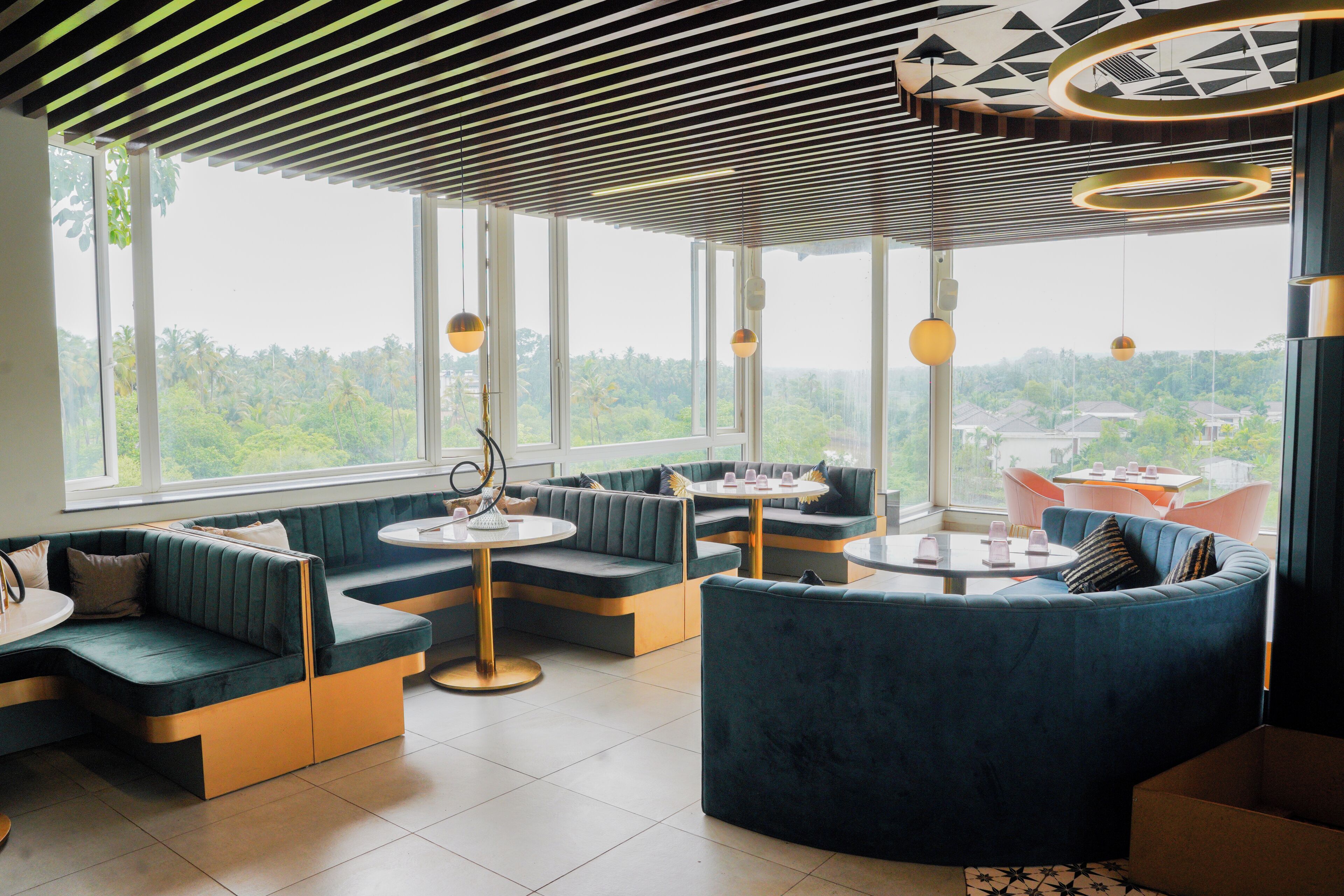 Un intérieur moderne avec des espaces de détente, de grandes fenêtres et des luminaires suspendus.