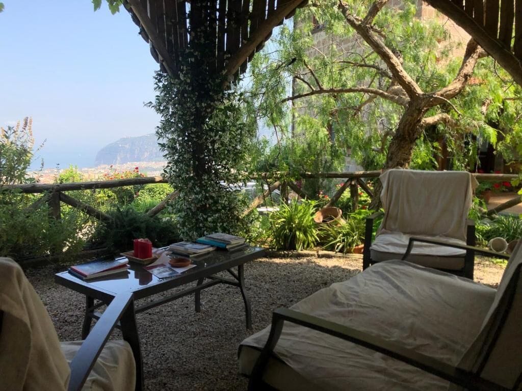 Un espacio al aire libre acogedor con una mesa, sillas y vistas al mar.