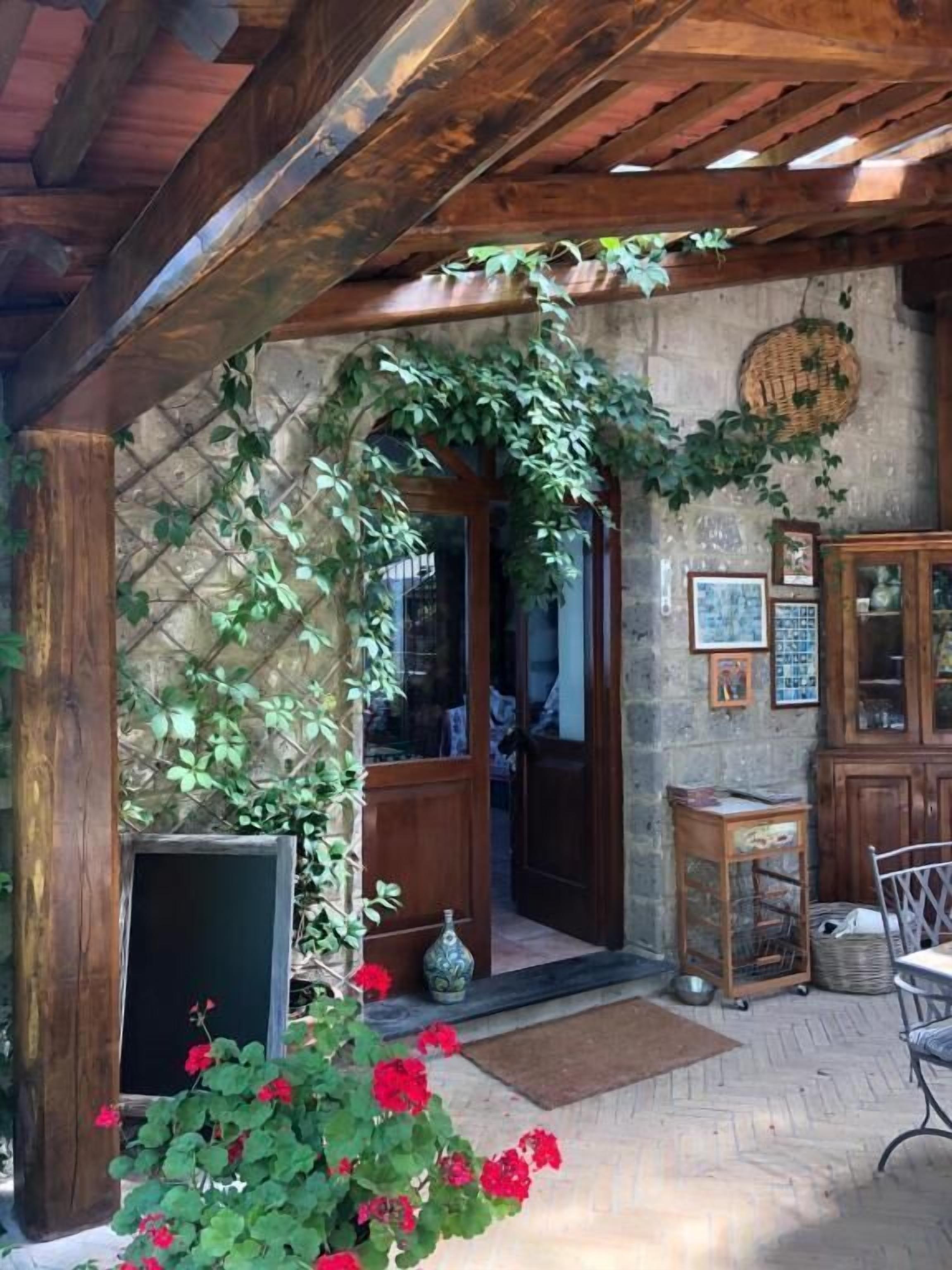 A rustic wooden structure with a door, a small table, and a chair.
