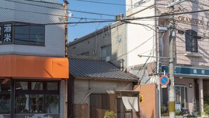 A street view with buildings, a no parking sign, and a pedestrian crossing.