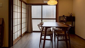 A traditional Japanese room with tatami flooring, a low wooden table, and shoji screens.