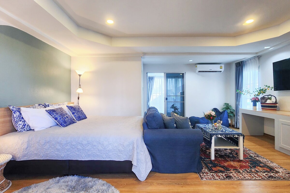 Una sala de estar moderna con sofá, cama, una mesita y televisor.