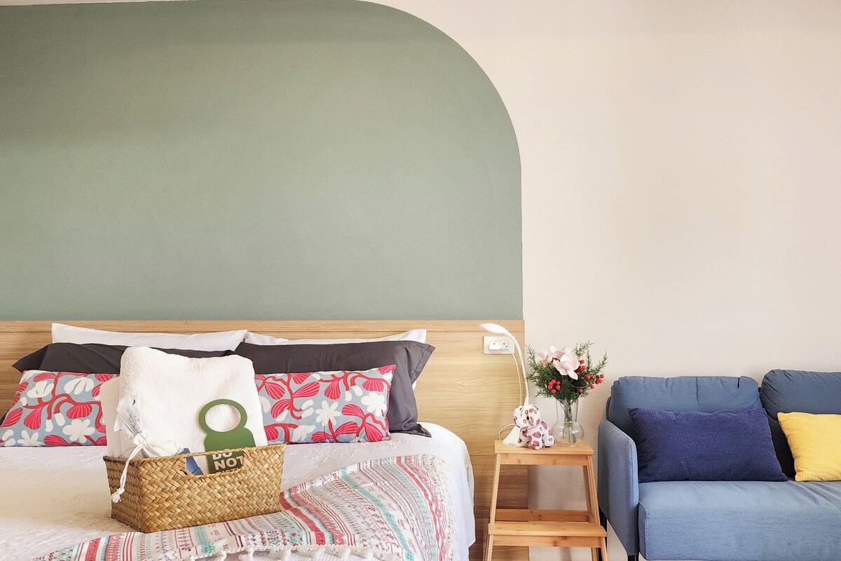 Un dormitorio con cama, mesita de noche y un sofá azul.