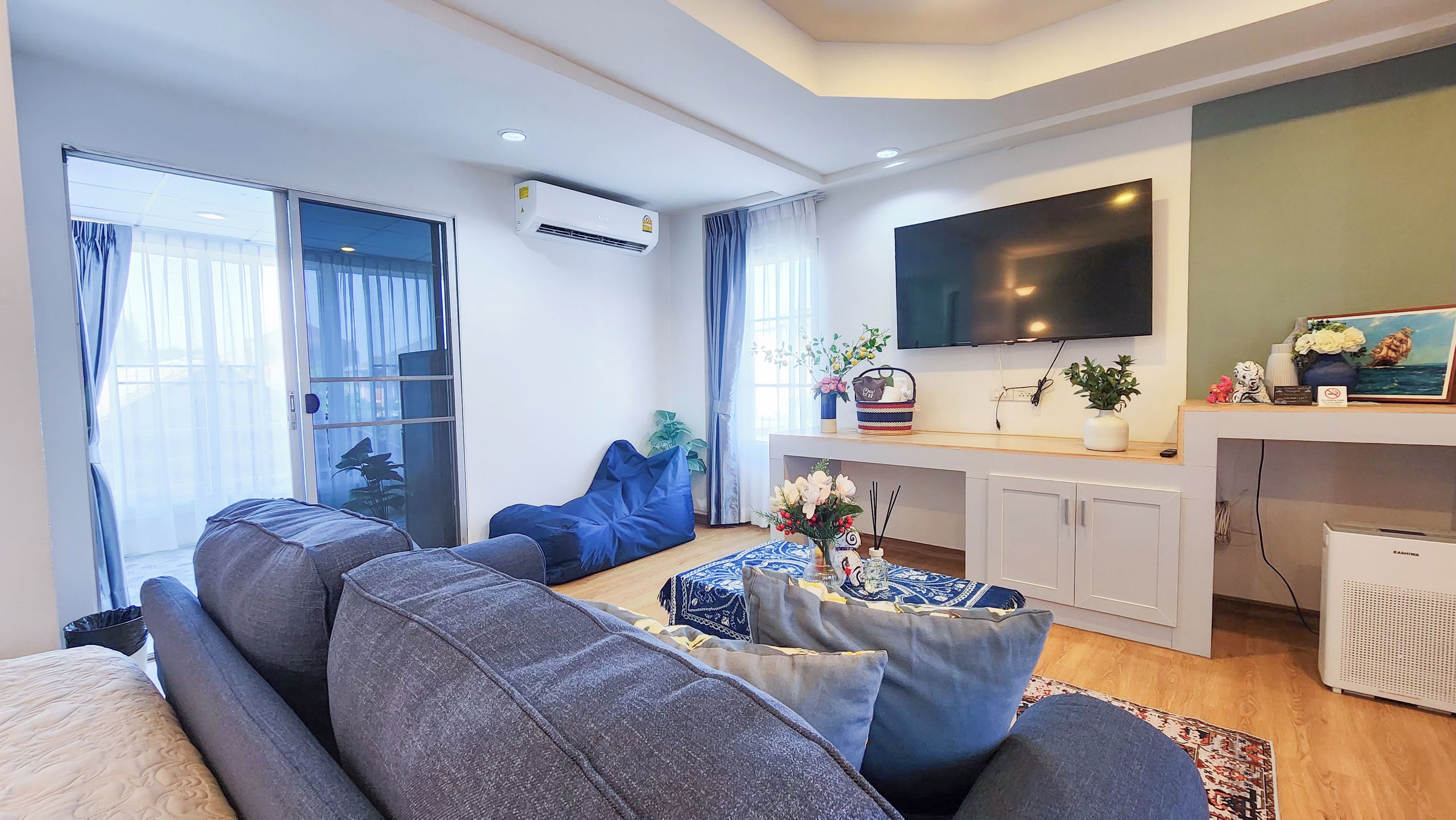 Ein modernes Wohnzimmer mit einer Couch, einem Couchtisch und einem flachbildfernseher an der Wand.
